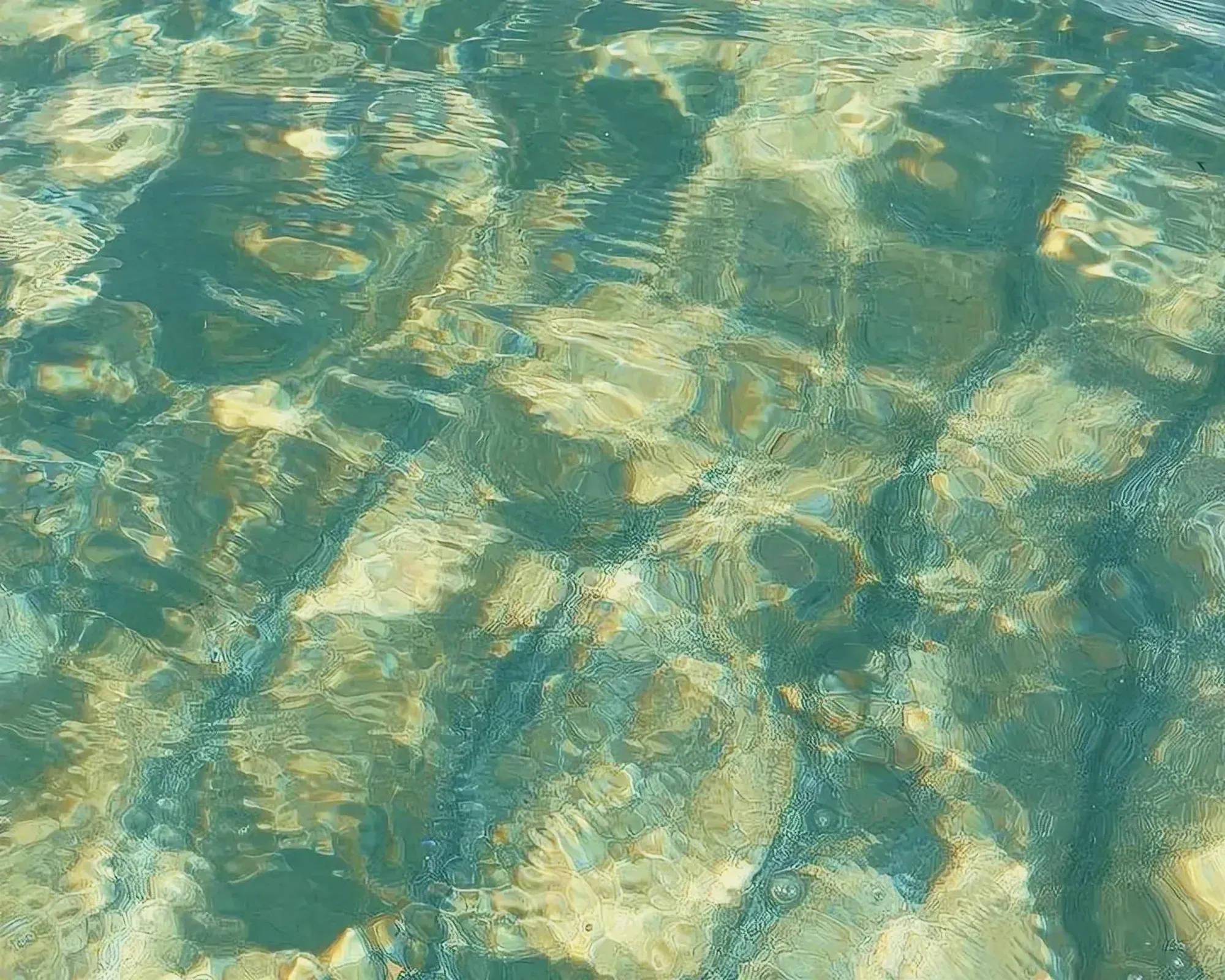 Clear water with underwater reef and dancing ripples