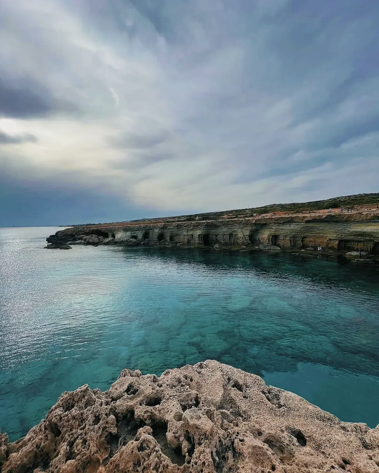 Rugged cliffside and tranquil water at Cape Greco National Park