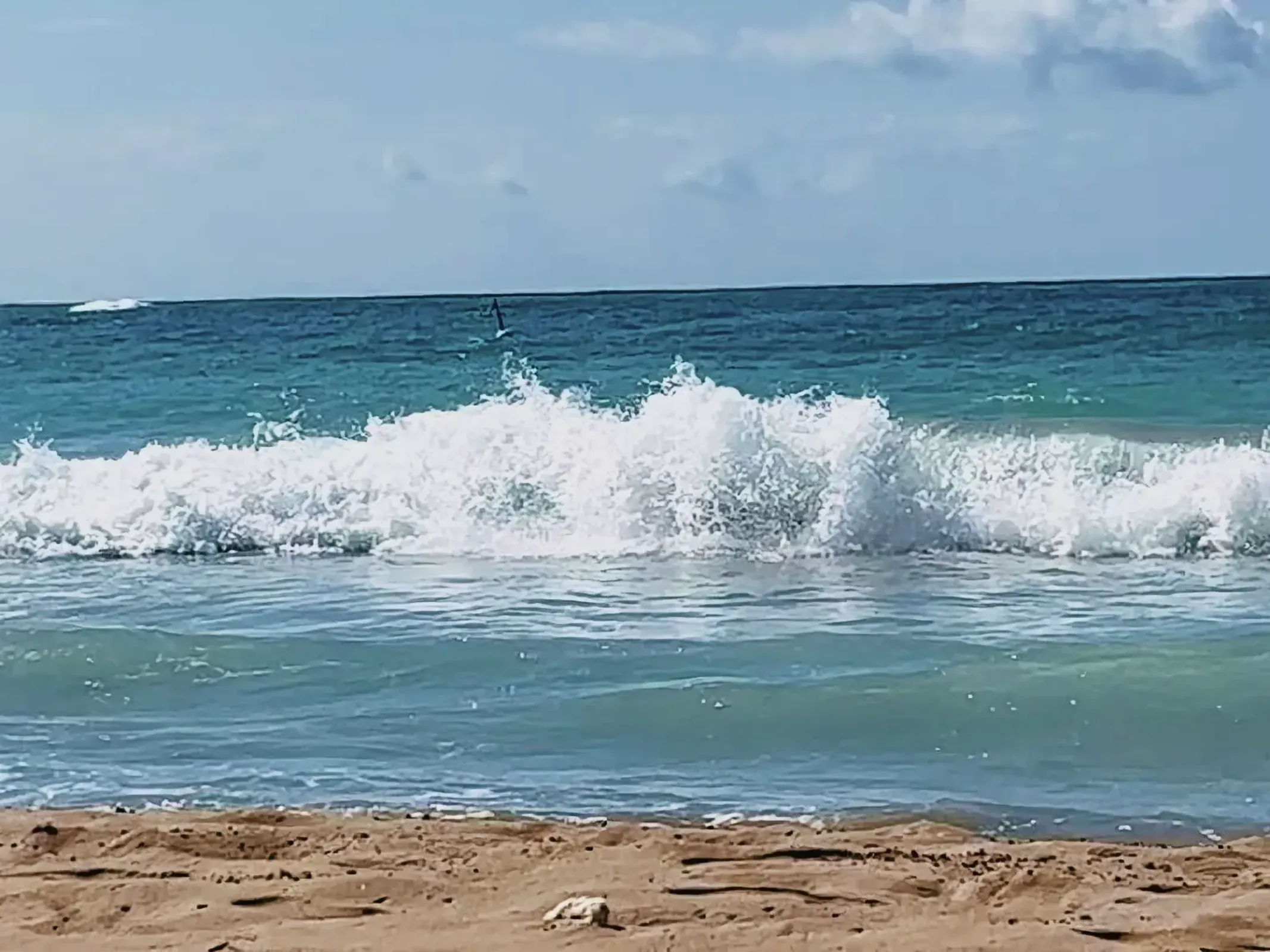 Captivating coastal landscape with powerful waves crashing onto sandy beach.