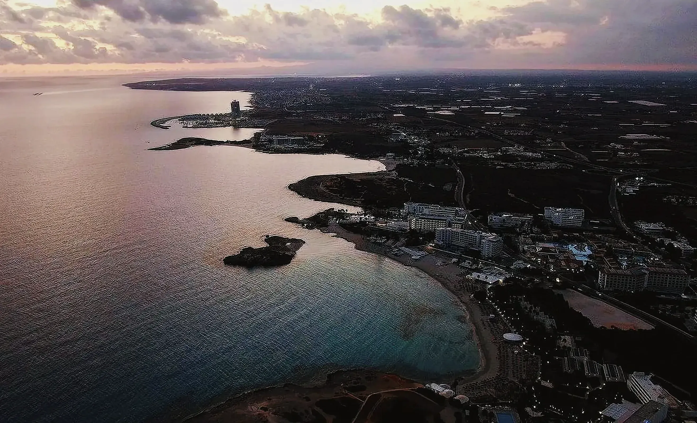 Aerial view of Nissi Beach in Ayia Napa, Cyprus with buildings along the shoreline.