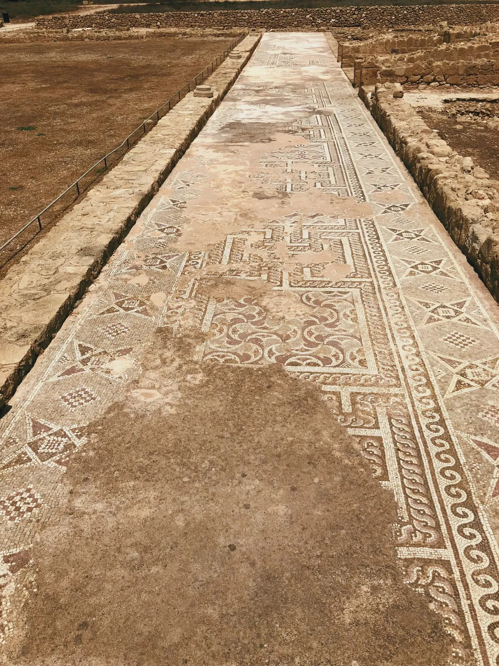 Intricate mosaic pattern in stone walkway at Nea Paphos