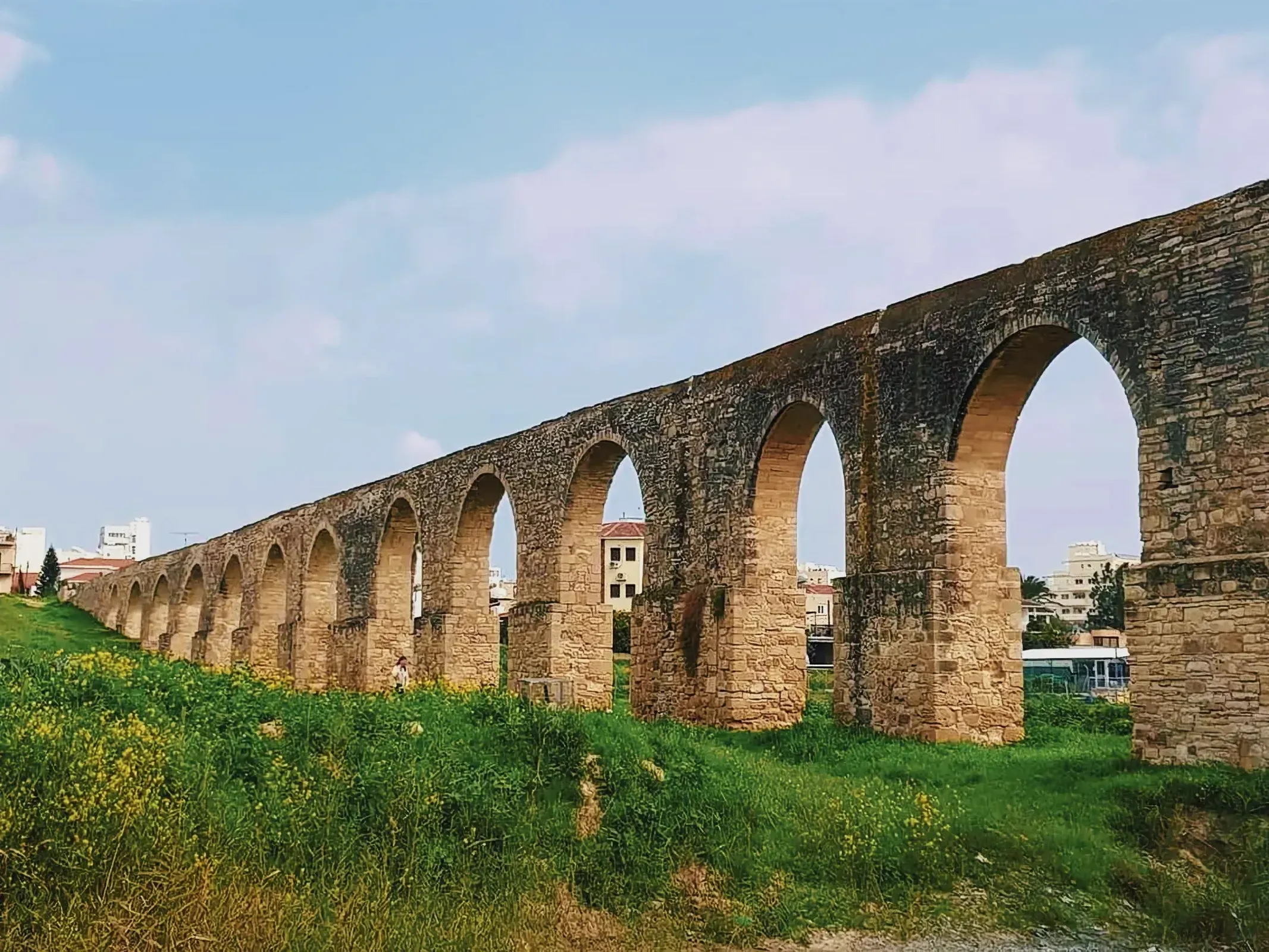 A stunning stone bridge with arches set against the Skopje Aqueduct in Larnaca, Cyprus.